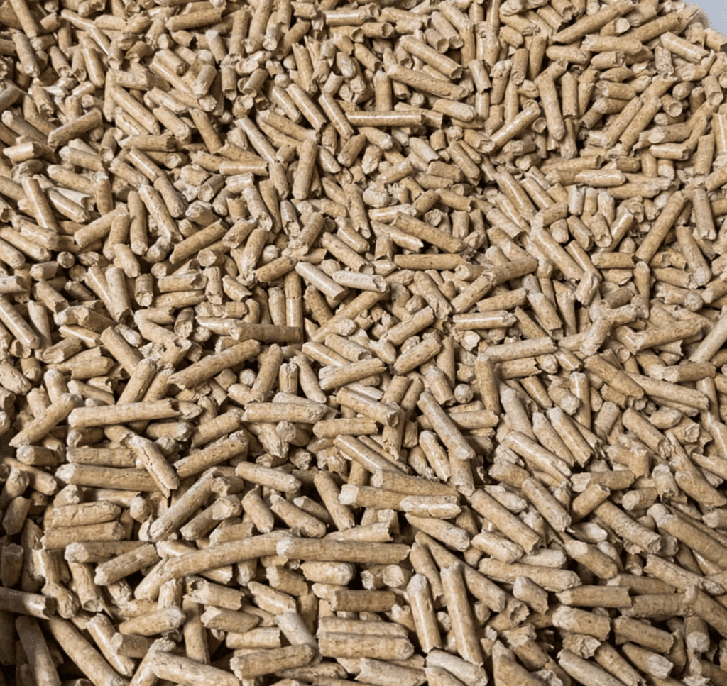 A close-up image shows a large pile of tightly packed, Pure Pine cylindrical wood pellets, often used as eco-friendly cat litter.