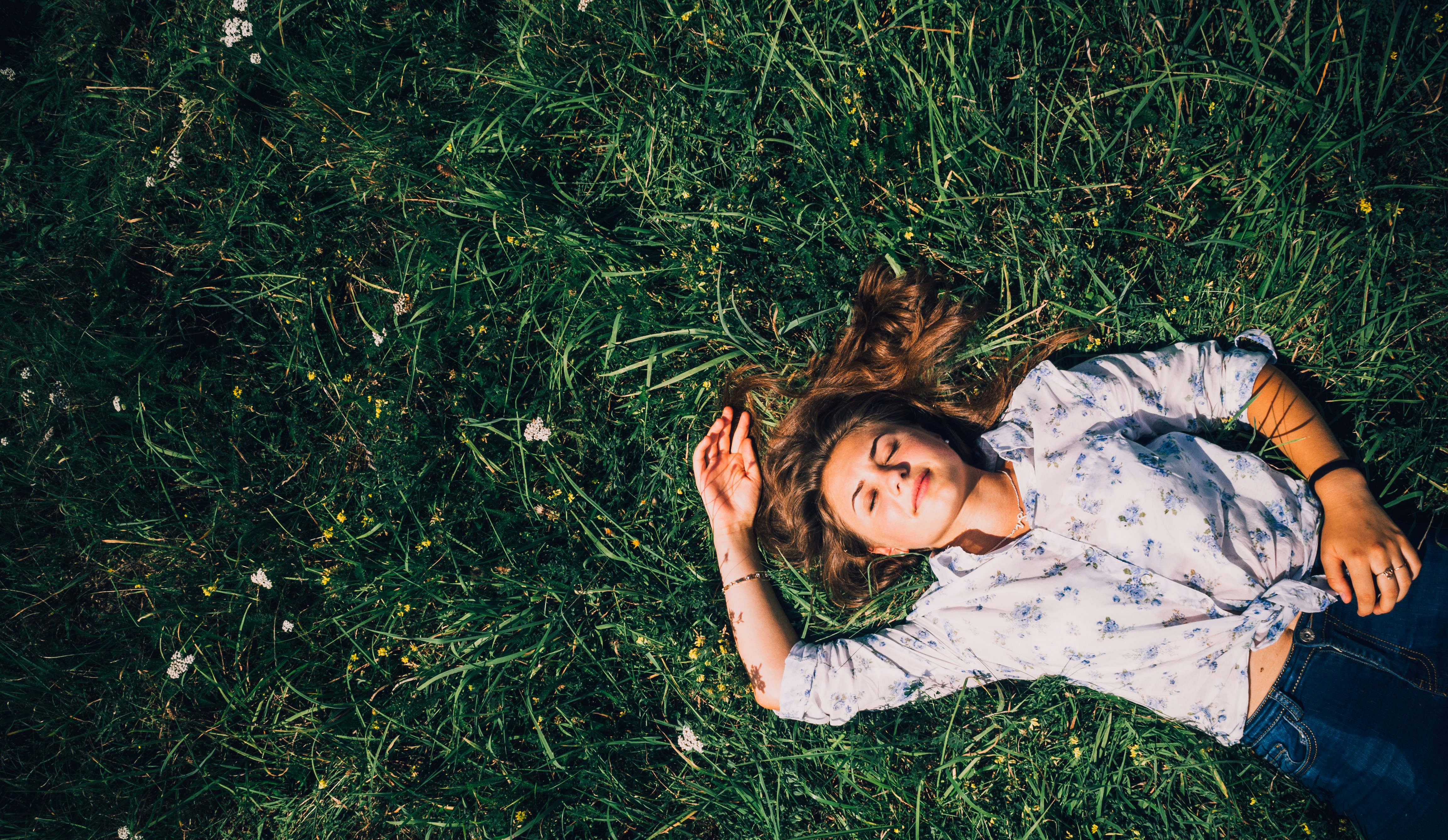 woman laying on grass looking up to the sky