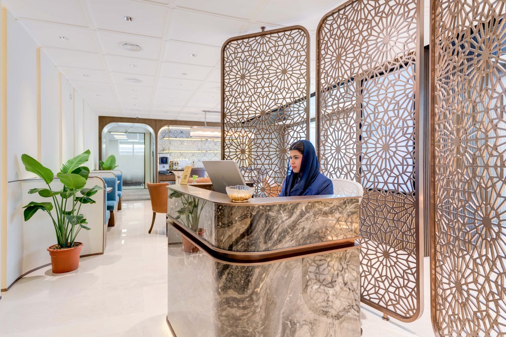 Remote work setup at TEC KSA with laptop and beverage in stylish coworking café