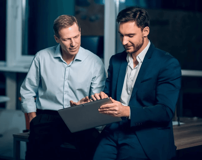 Dois homens segurando um tablet acessando produtos digitais Elevare