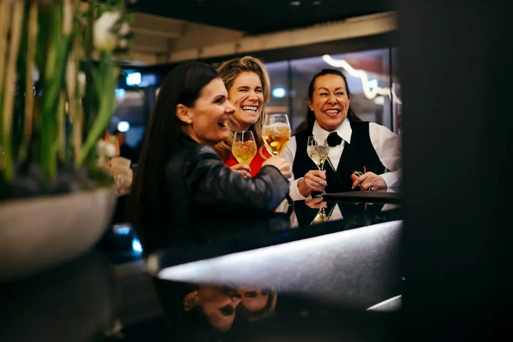 People in the Porsche Tunnelclub inside the MHP Arena sitting at the Targa Bar