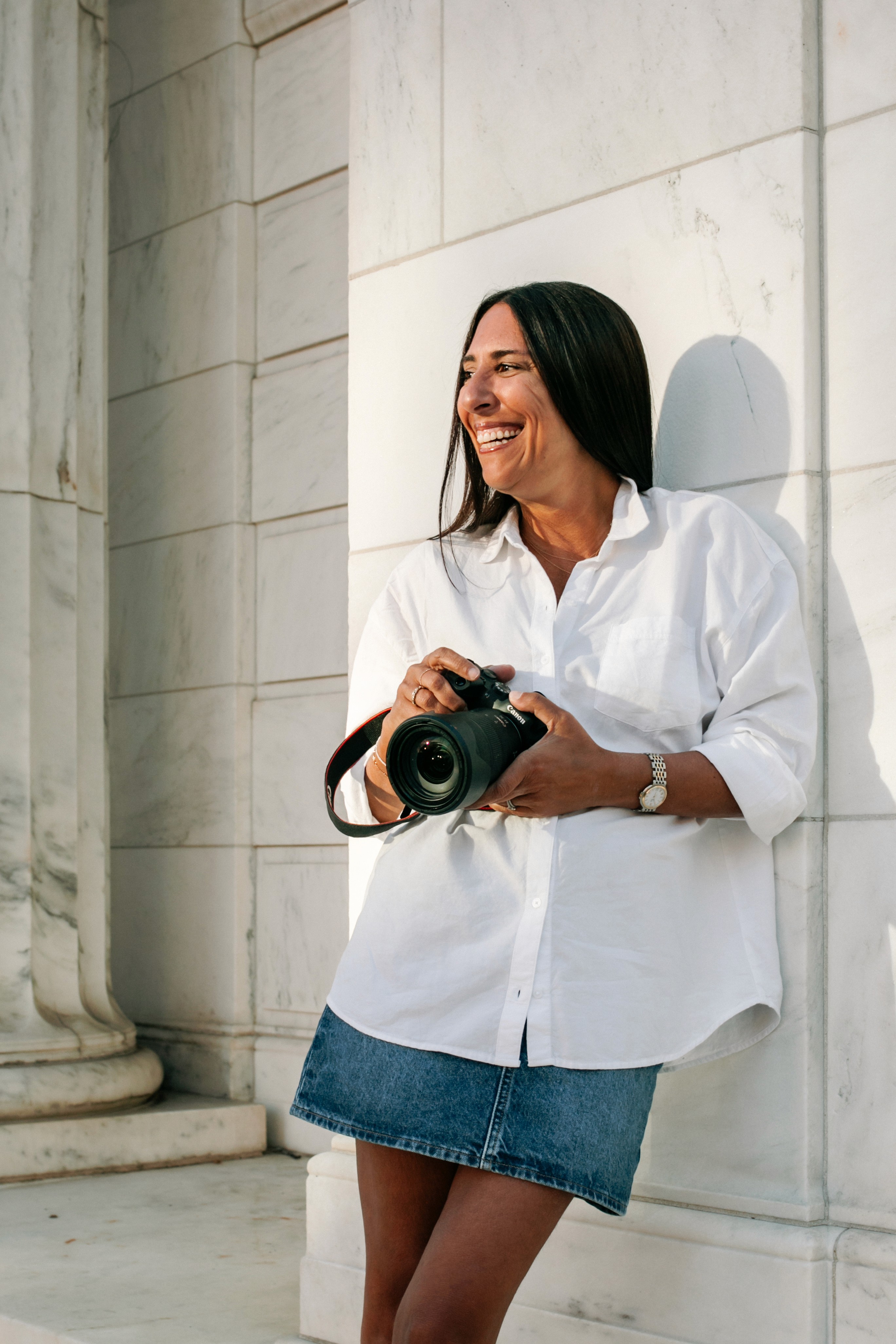 Lizz Spano, New York City and Saratoga Springs photographer, smiling candidly with camera in hand — natural light portrait of the woman behind Lizz Spano Photography.