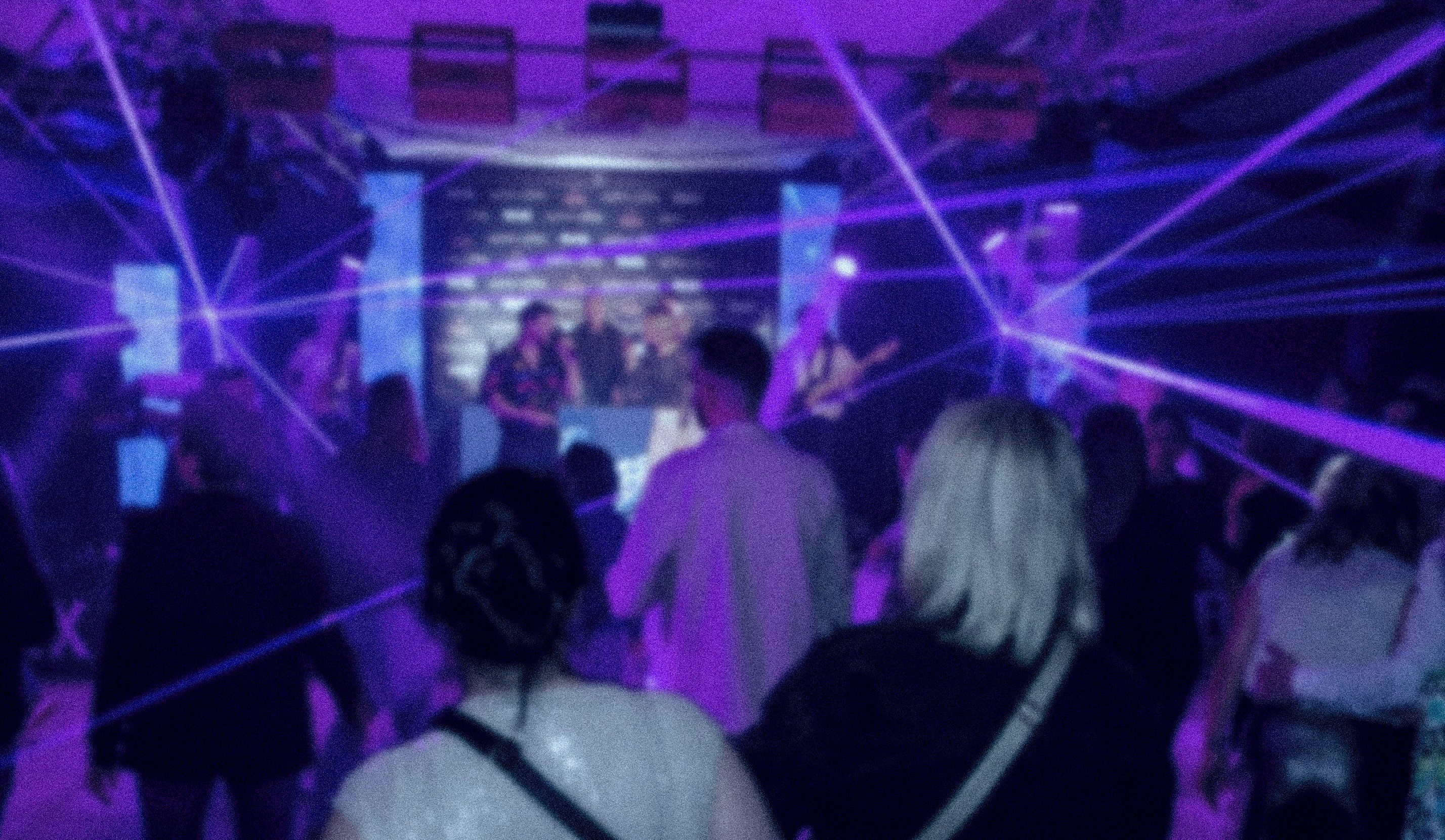 Modern indoor space with large glass doors, lush greenery, and a cozy seating area visible beyond.