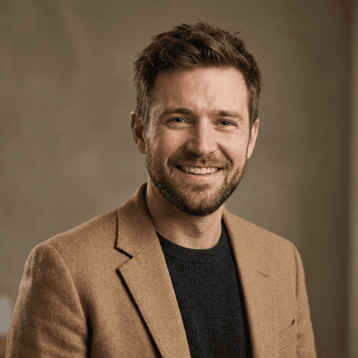 Smiling man in brown blazer professional portrait