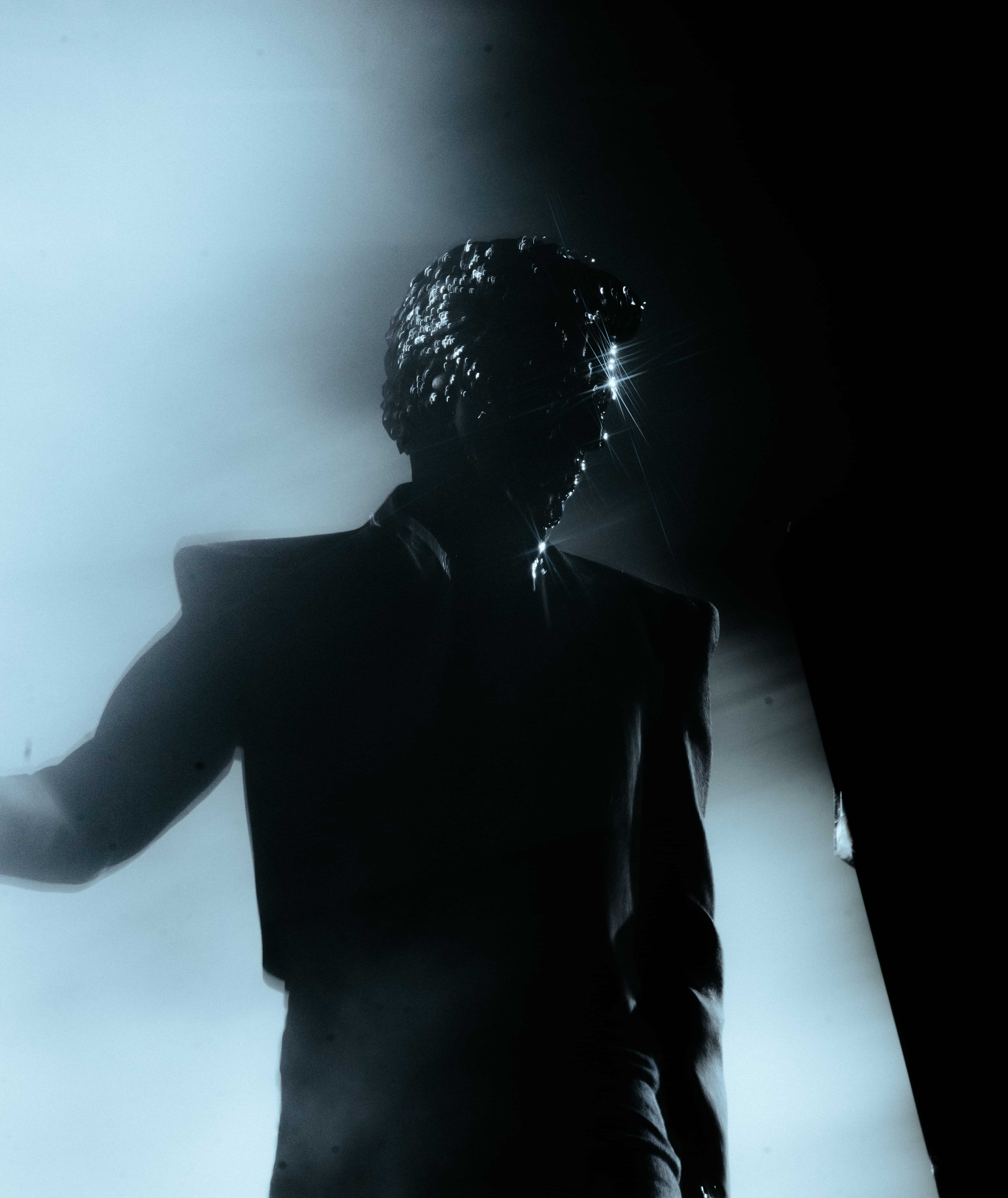 Gesaffelstein performing at Coachella 2024 in silhouette with reflective mask under dramatic lighting, captured by A World Away creative director Brandon Densley