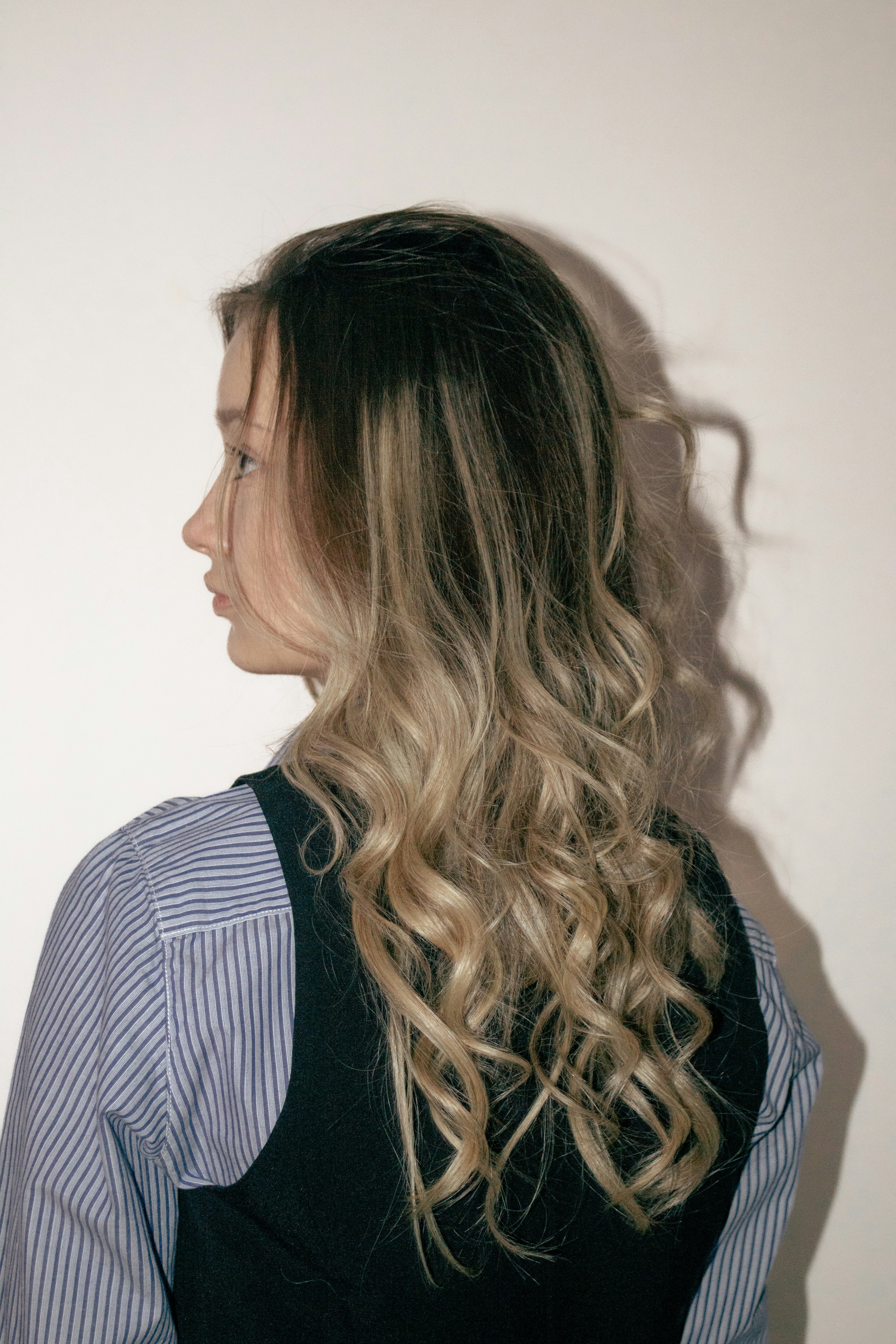 A woman with curly hair looks to the side.