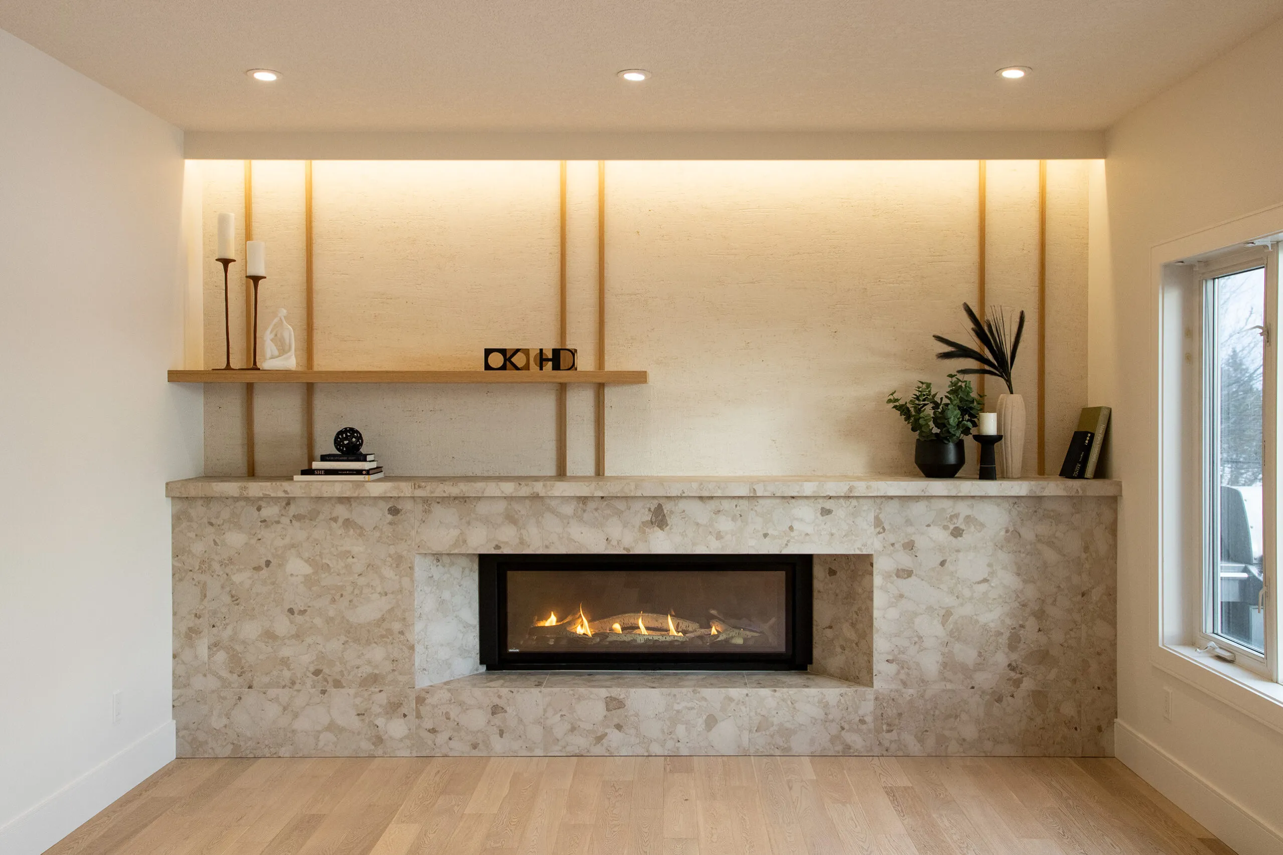 Image of KHD Homes design-build interior with modern fireplace, stone surround, and shelf, showcasing layout design expertise.