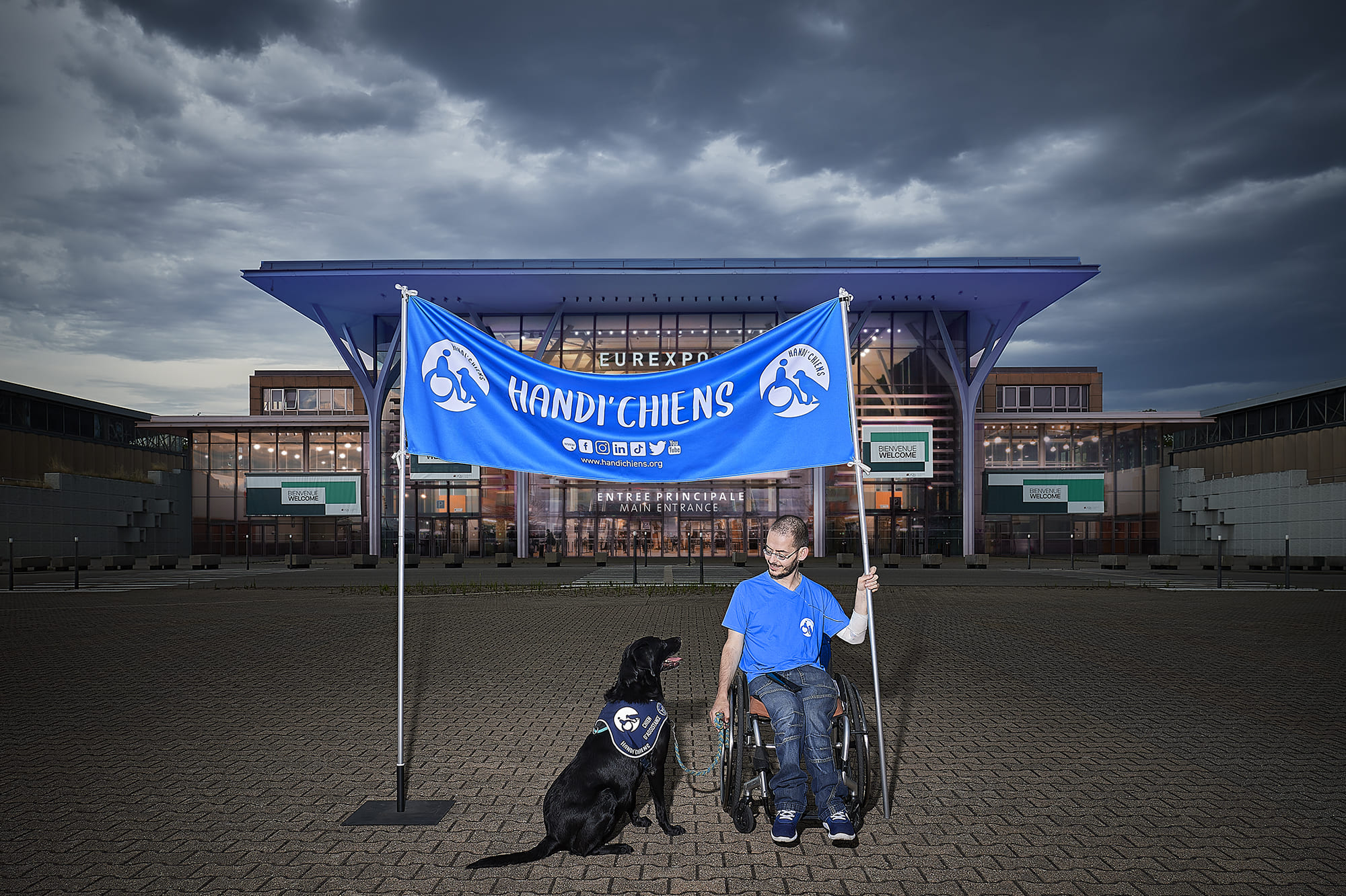 Jean-Pierre accompagné de son chien d’assistance Irun, photographiés par Frédéric Bourcier à Eurexpo Lyon dans le cadre d’un reportage documentaire social pour Handi’Chiens