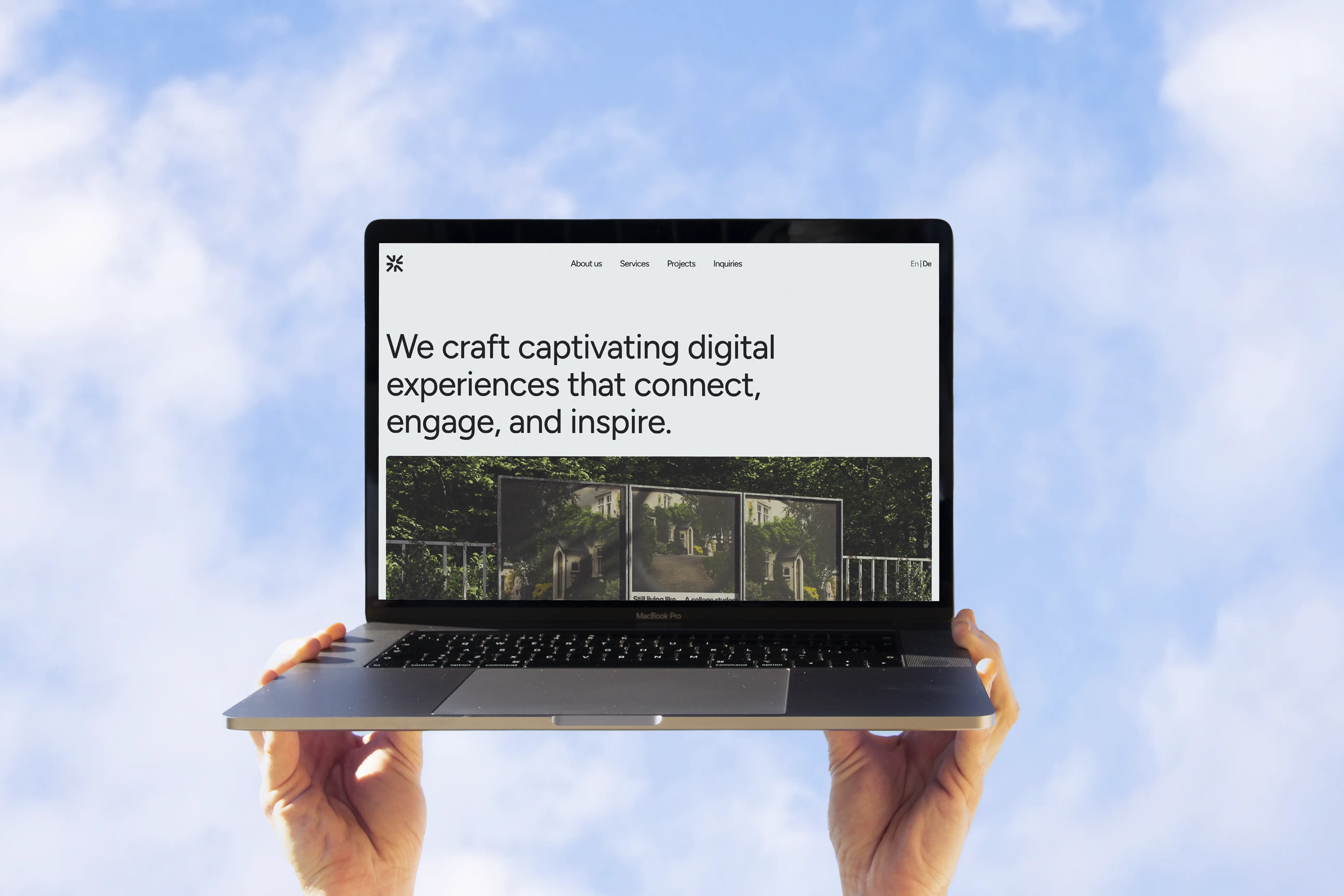 Laptop displaying Foci Studio's homepage with the tagline 'We craft captivating digital experiences' held against a bright sky background.