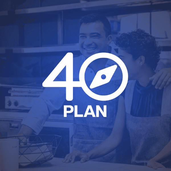 Two men reviewing documents together by a large window, with sunlight streaming in.