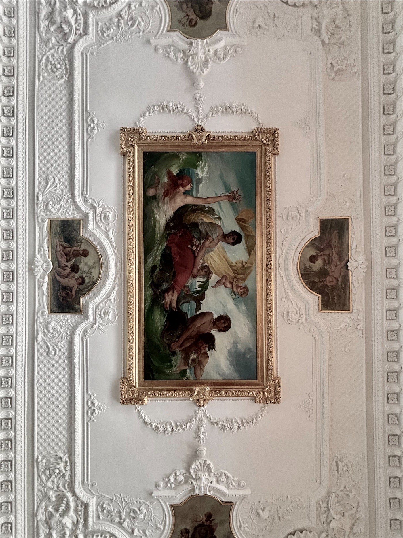 A painted panel in a white stucco ceiling