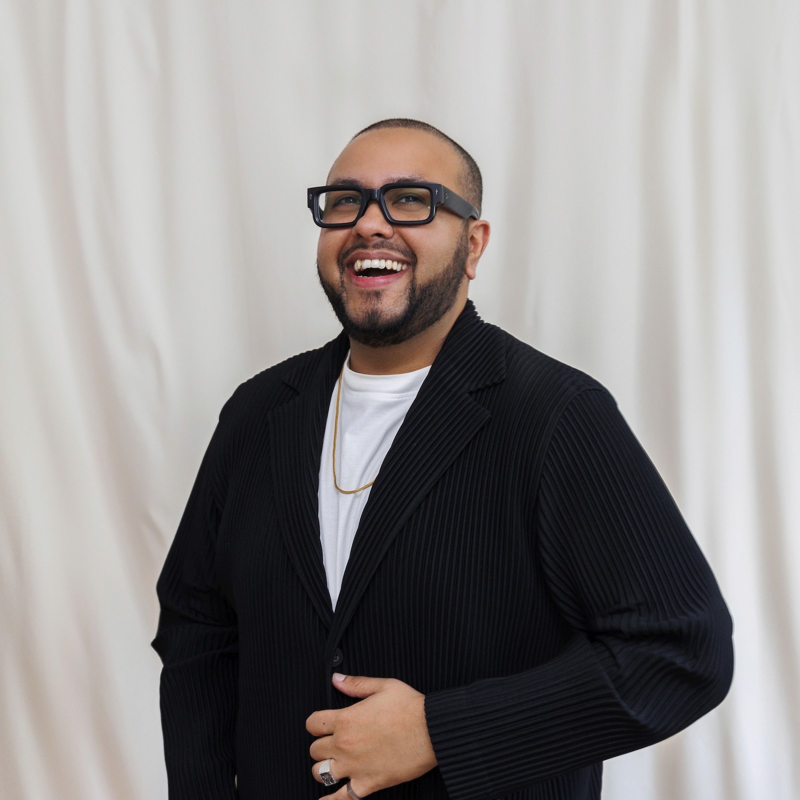 Portrait of Dinesh Dave, Design Director and co-founder of Proof Dept, standing indoors in soft natural light.