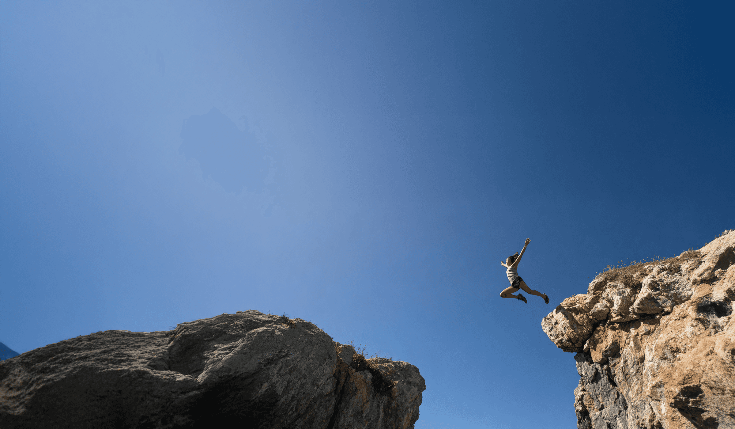 A woman jumping from a cliff suggesting freedom