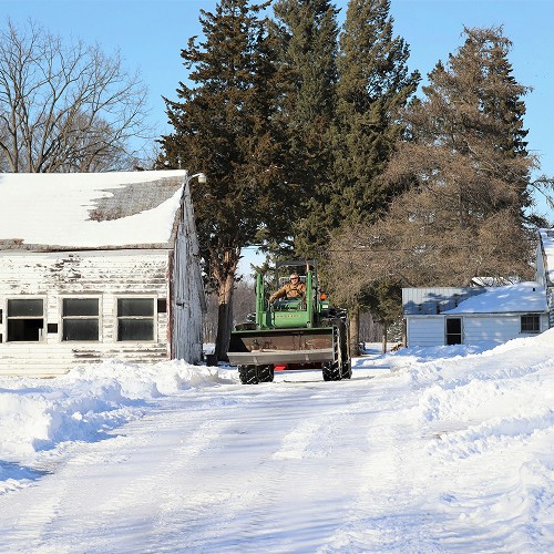 Landscaper driving tractor in snow