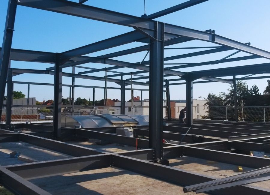 Charpente métallique en cours de montage sur chantier, vue intérieure de la structure acier.