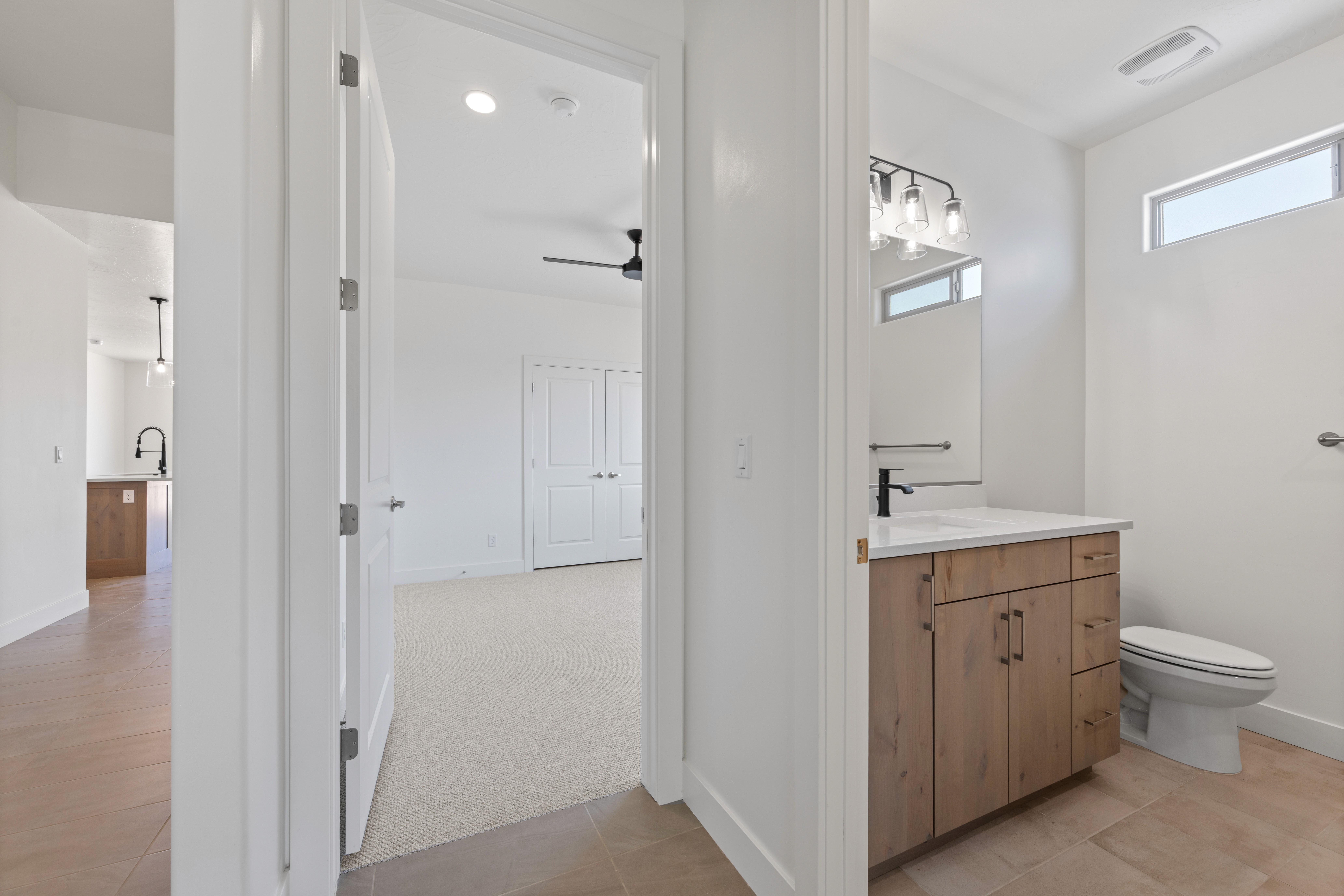 Additional bedroom or flex space next to a hall bathroom in The Nest at Falcon Ridge in Hurricane, Utah, highlighting natural light and versatile design.