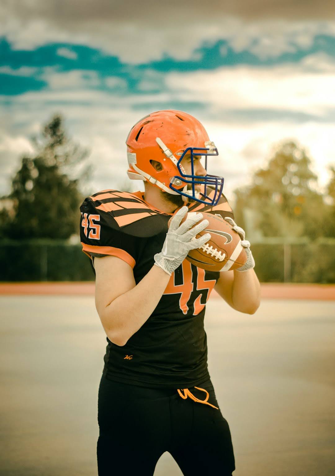 A football player wearing an orange and black uniform, representing Super Bowl LIX and Beyond, poised for action on the field.