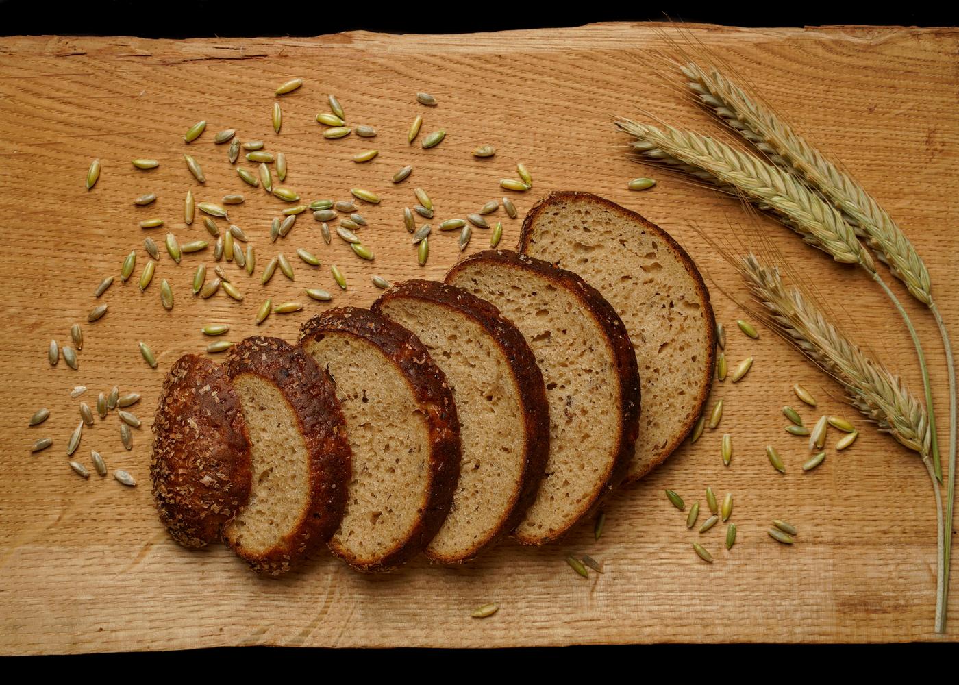 Whole grain bread and oats on a wodden surface