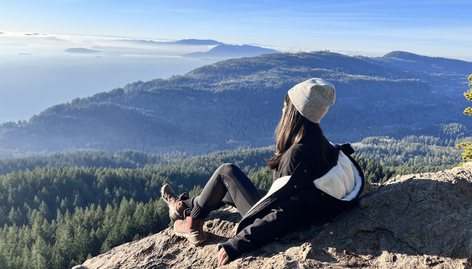 A close-up of a hand wearing multiple decorative rings against a blue background.