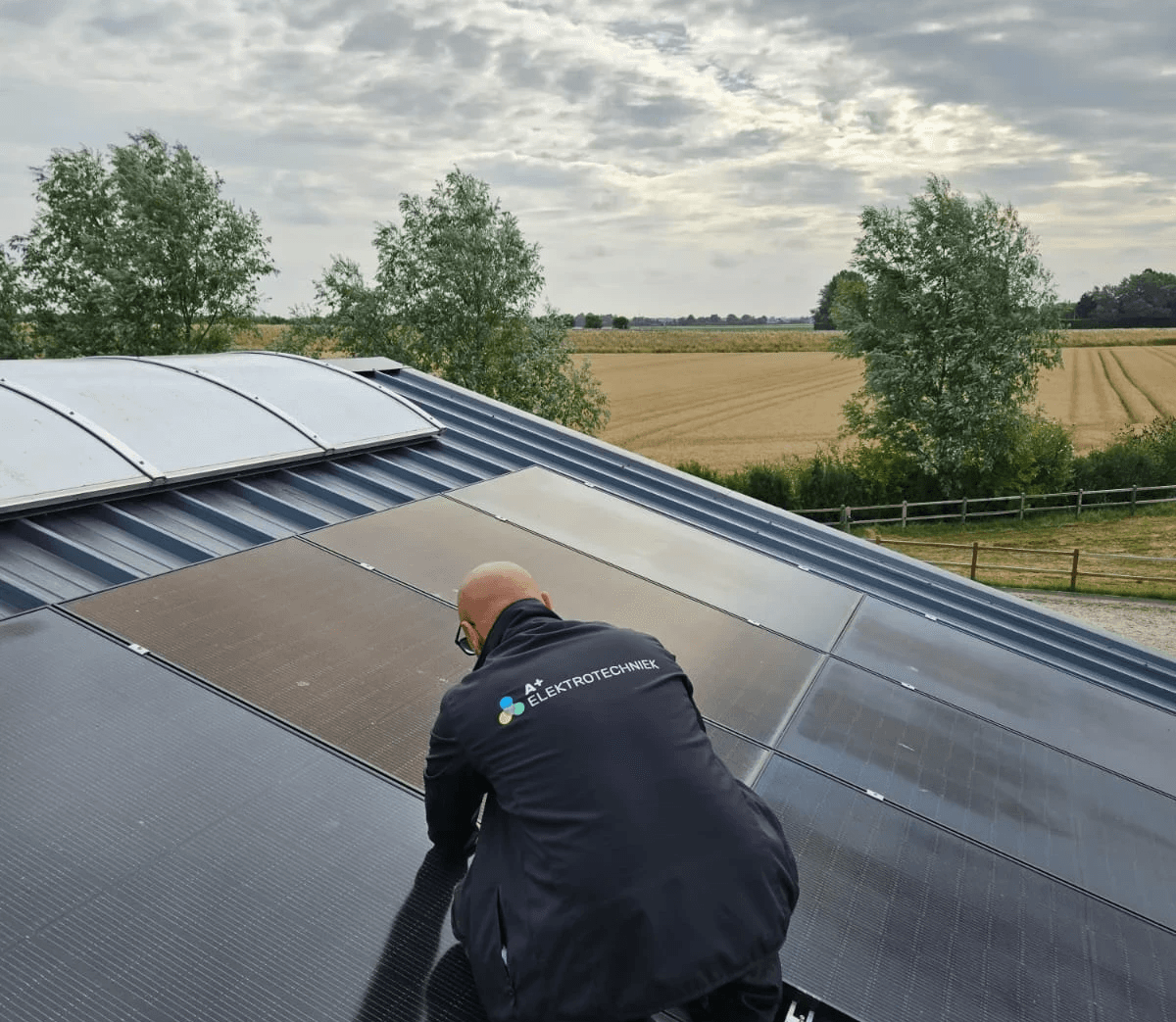 A+ Elektrotechniek medewerker monteert een zonnepaneel