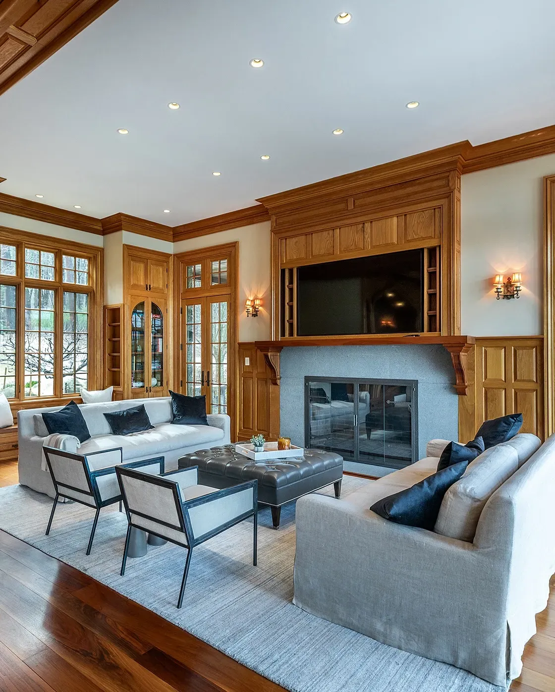 Warm living area with a stone fireplace, wooden beams, and comfortable seating arranged around a coffee table.