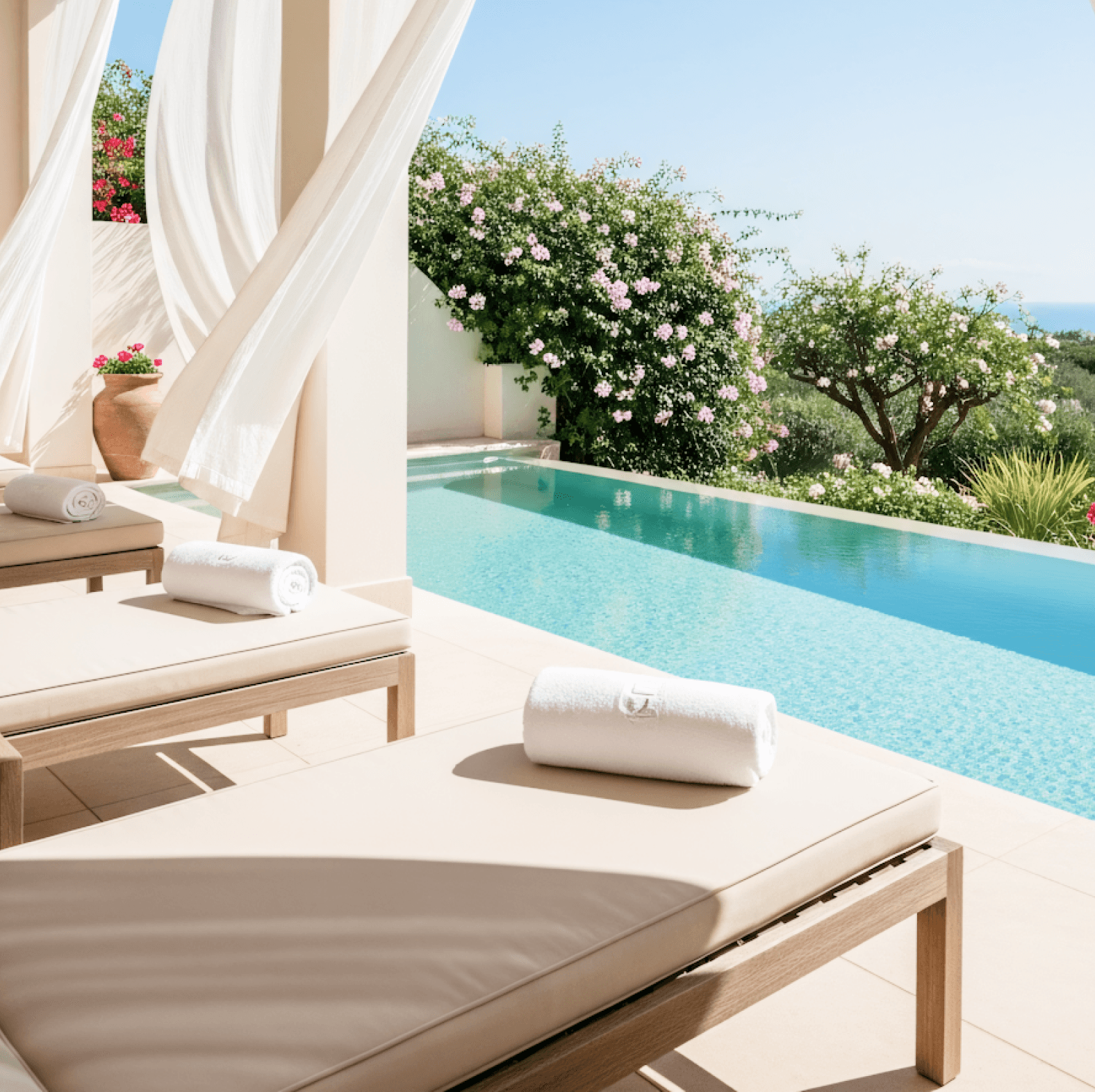 Peaceful poolside lounge with sunbeds, flowing curtains, and garden view overlooking the sea.