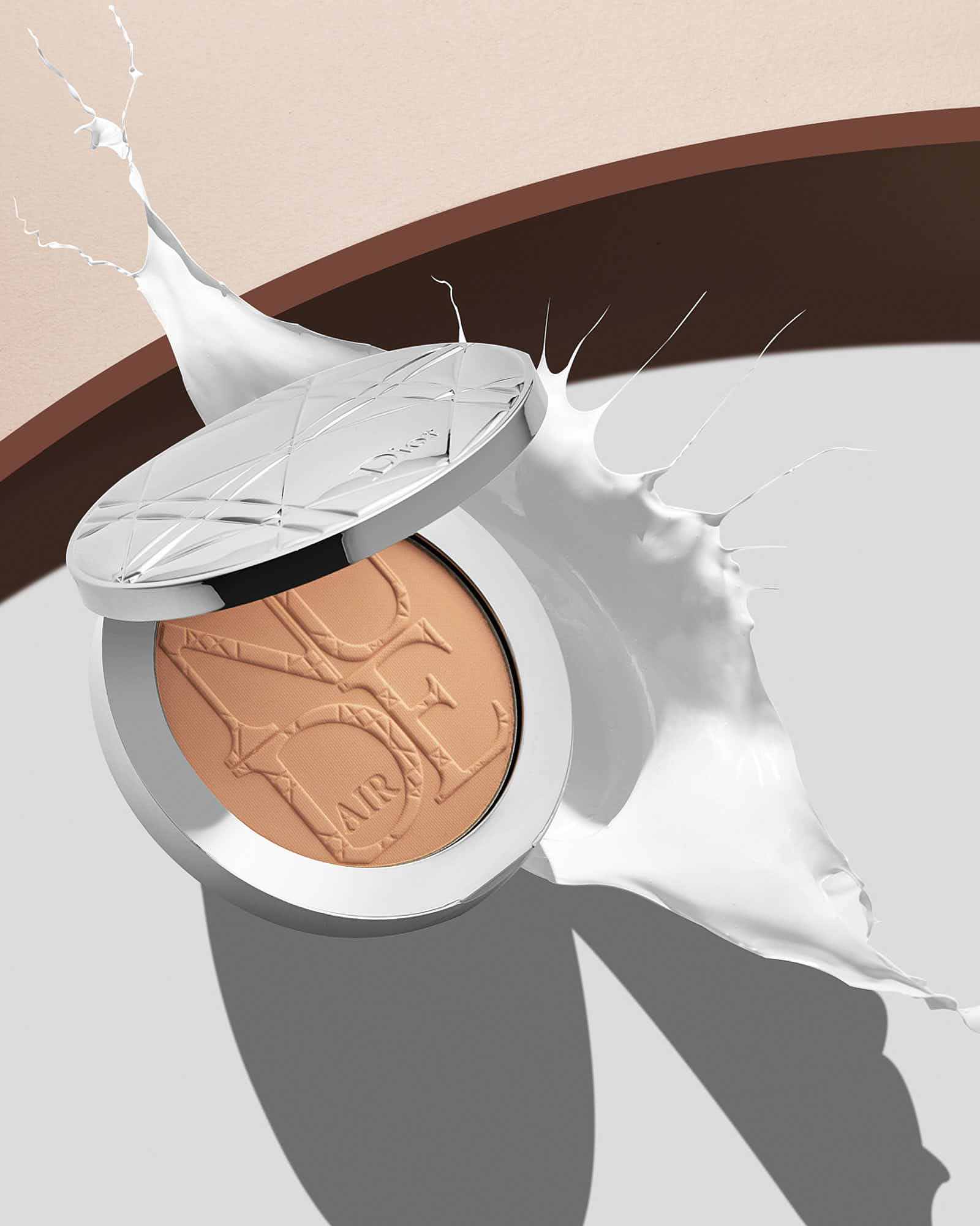 A close-up of a falling cosmetic foundation into cream