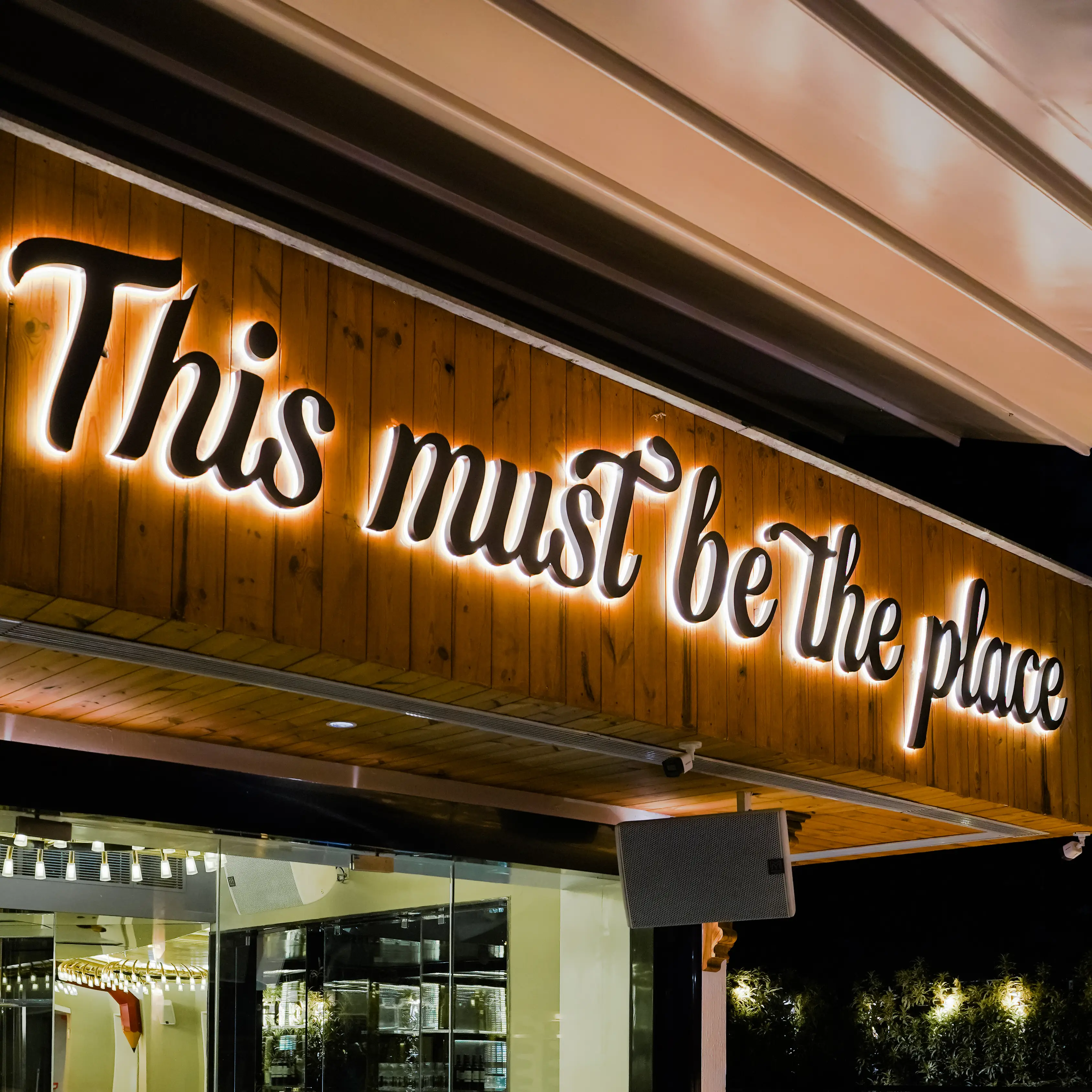 restaurant illuminated signage on wooden facade at night with premium dining ambiance