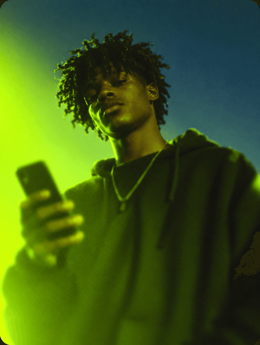 Black man holding a phone in lime-green lighting
