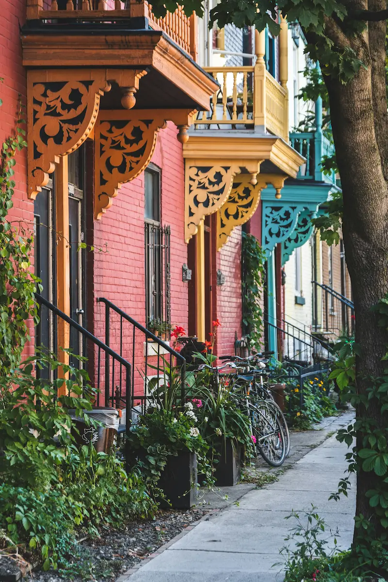 Colourful row houses and ornate balconies on a leafy Montreal residential street