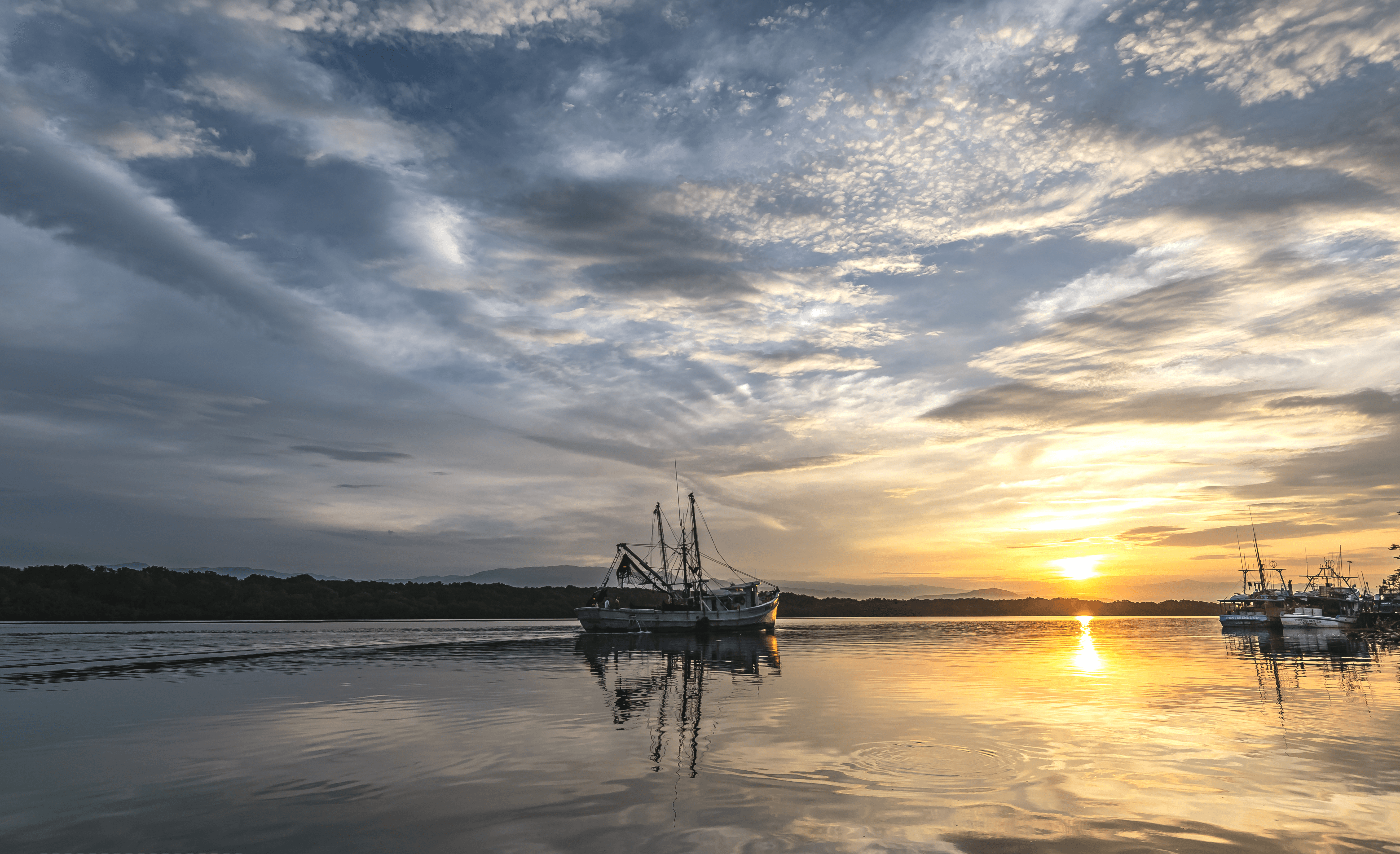 Fishing vessel at sea during sunrise