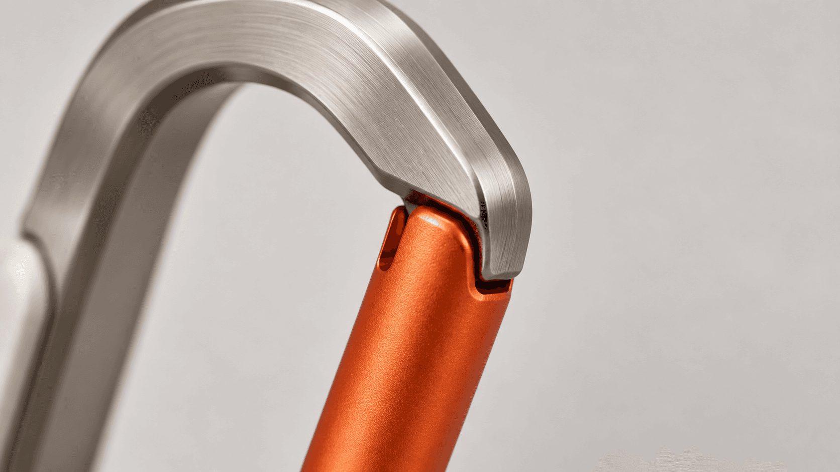 Close-up of the KROK carabiner’s curved aluminium frame and orange gate