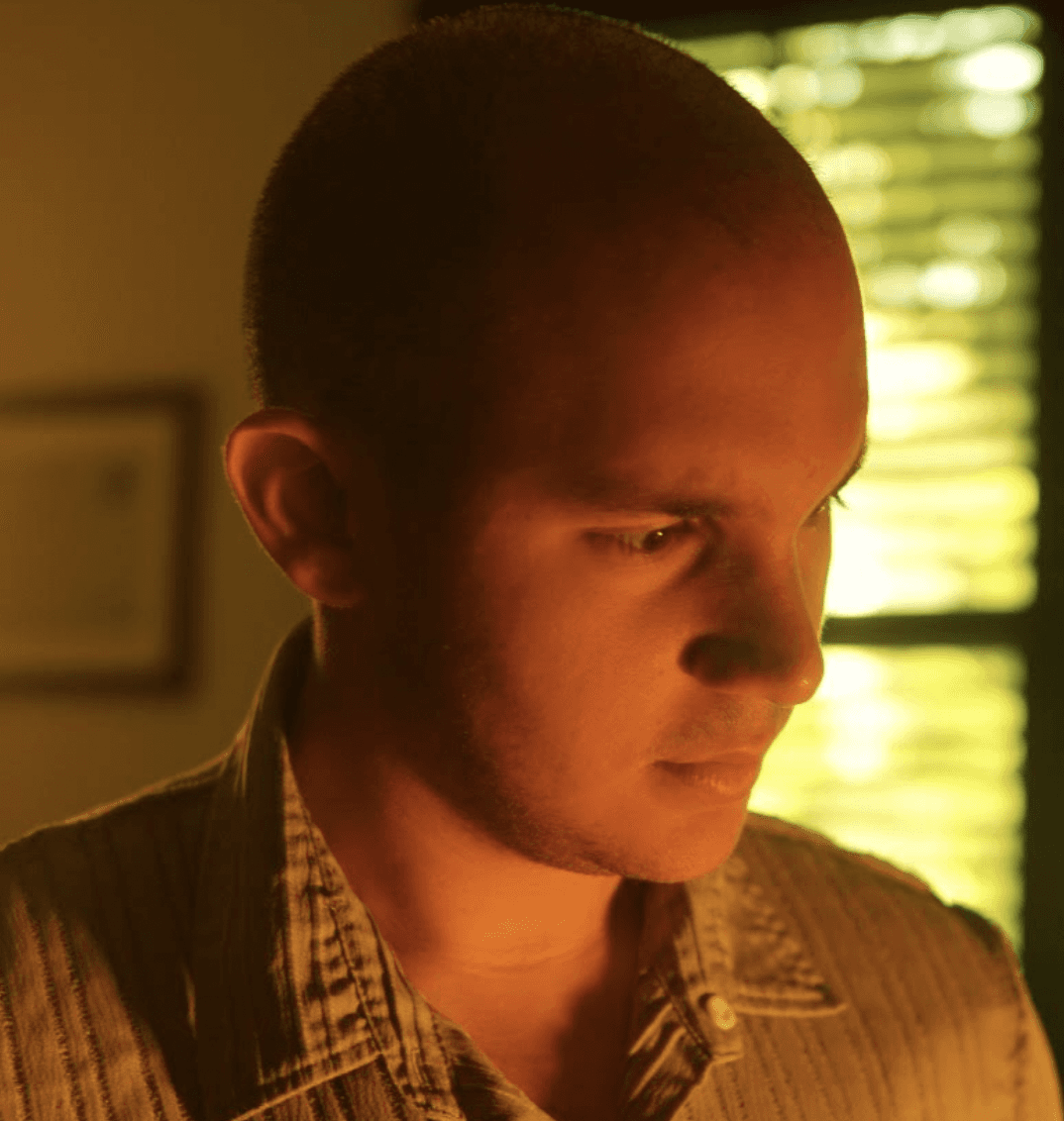 Woman in a light suit sitting thoughtfully against a terracotta wall