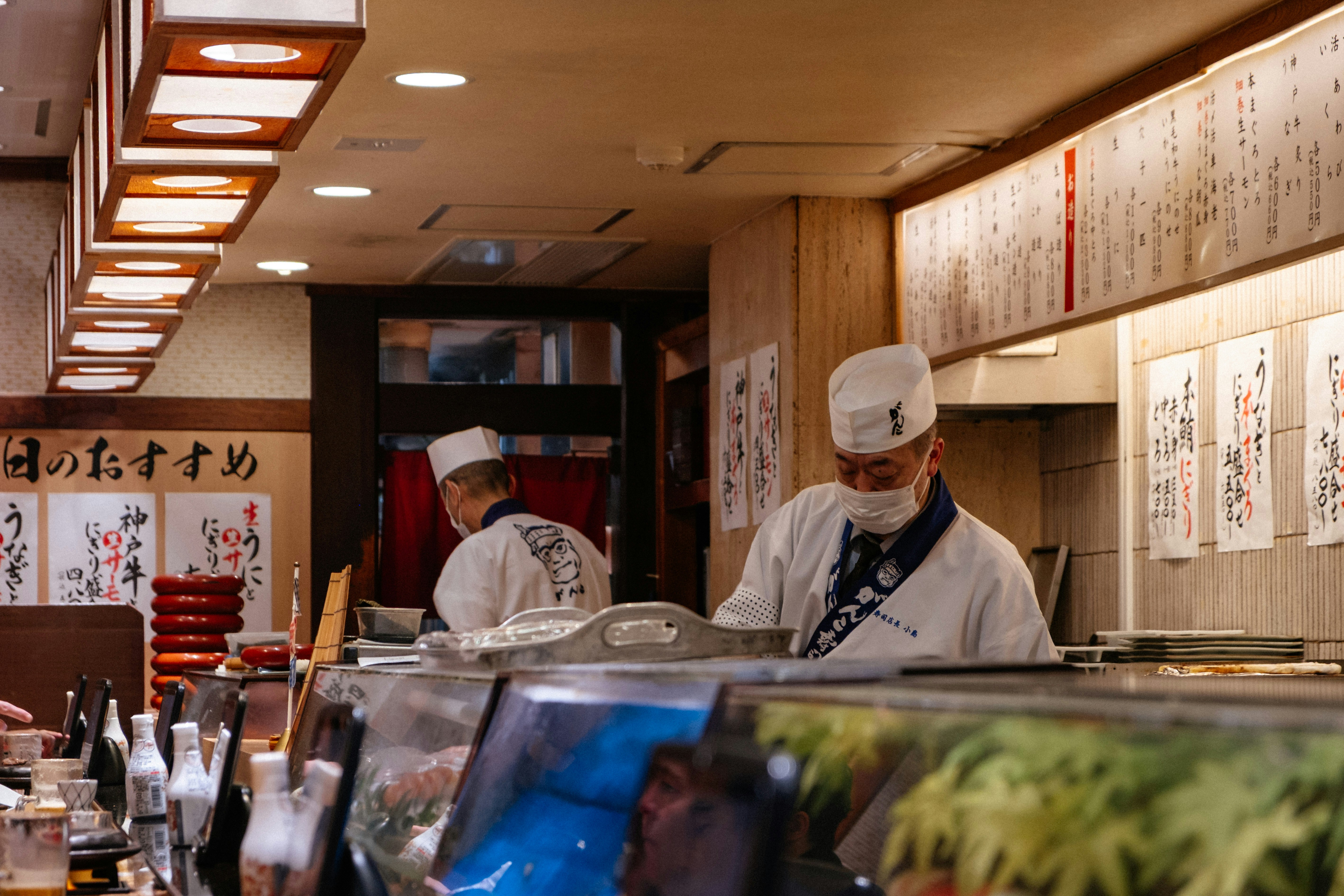 Sushi chefs preparing food in a japanese restaurant.