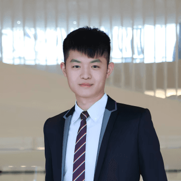 smiling man wearing black turtleneck shirt holding camrea