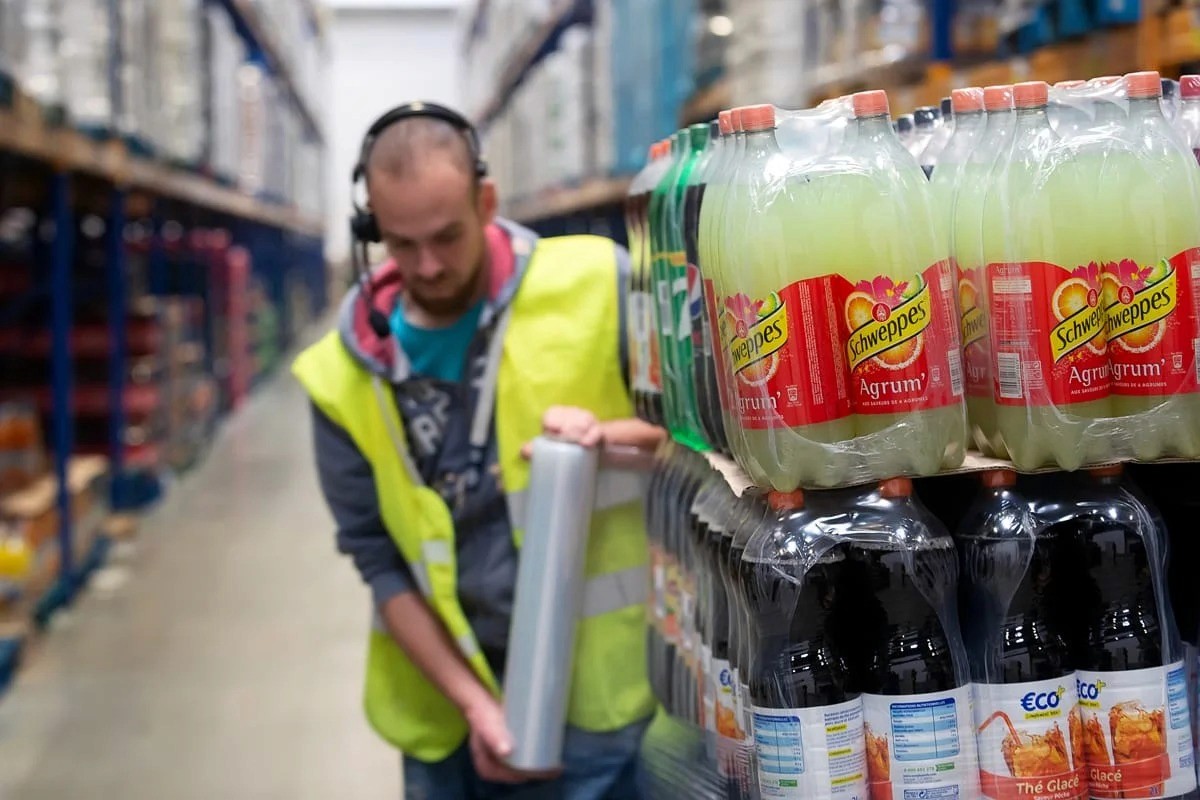Employé logistique déplaçant palettes boissons en entrepôt — photo industrie Lille Nord | Anteale Yann Manac’h 2025
