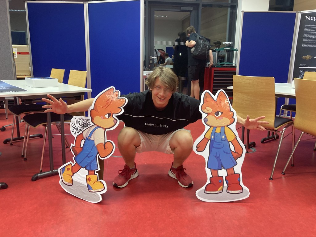 Jasper Freh posing with cardboard cutouts of Carl and Cari from Carl und Cari: Trubel in Tierstadt