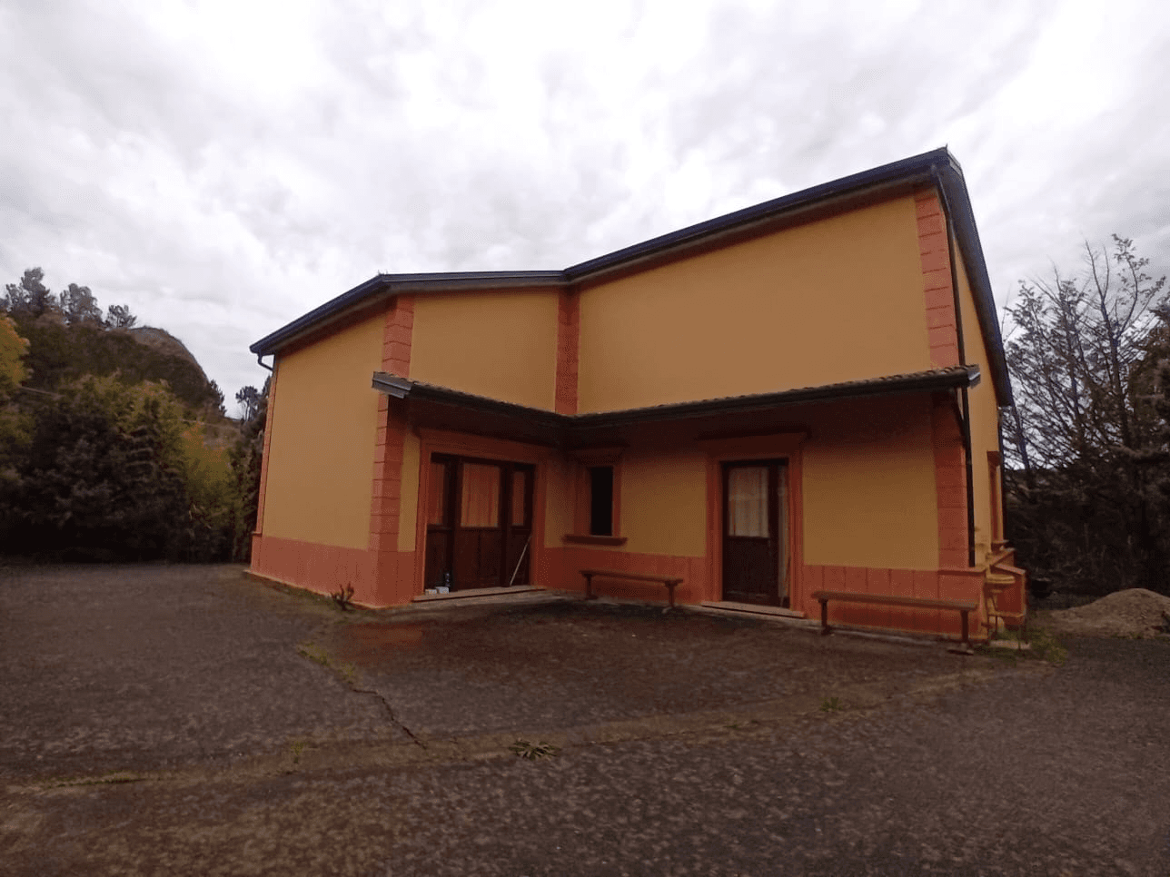 A modern brick house with a two-car garage, well-manicured lawn, and clear blue sky in the background.