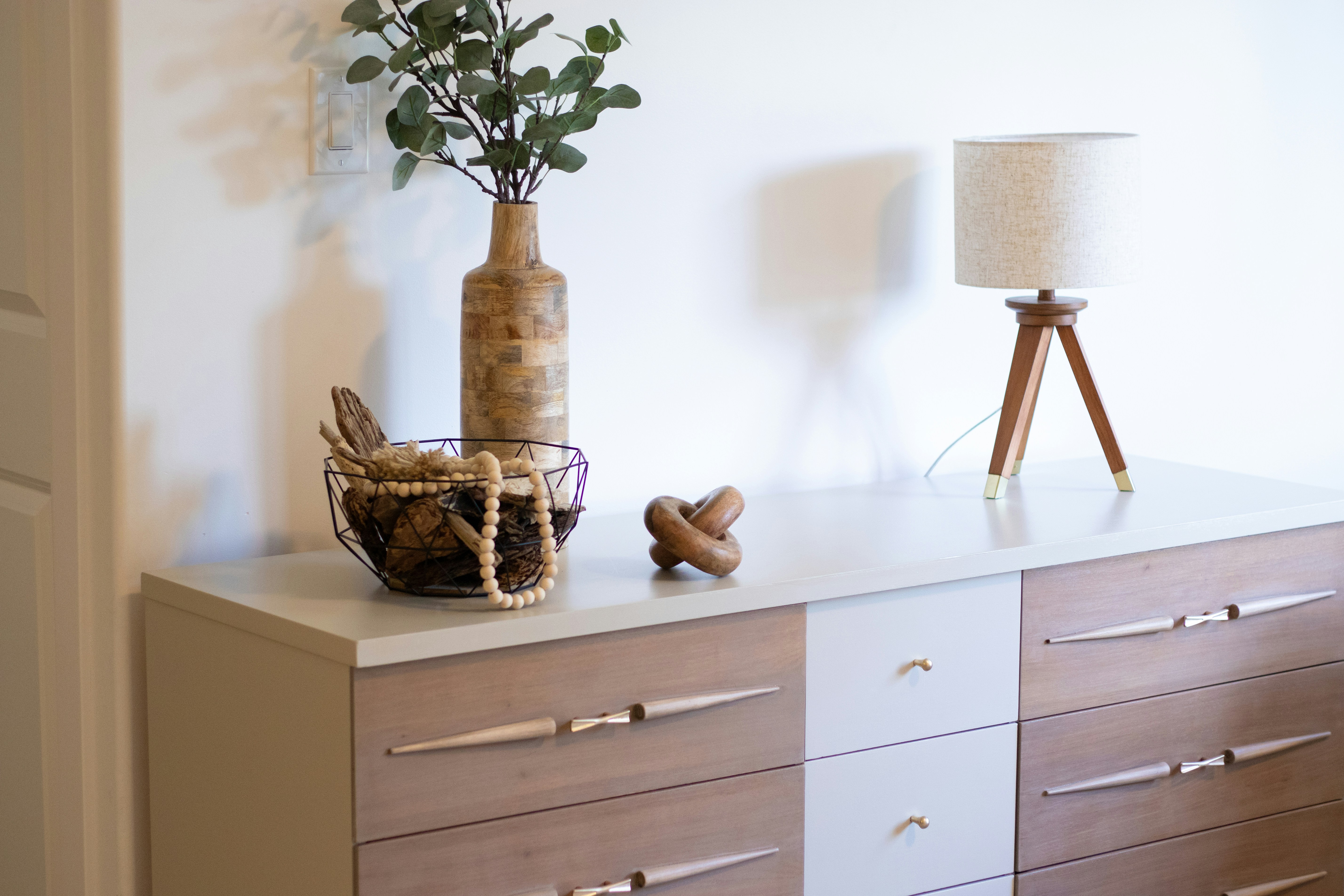 Scandinavian living room with beige sofa, armchair, plants.
