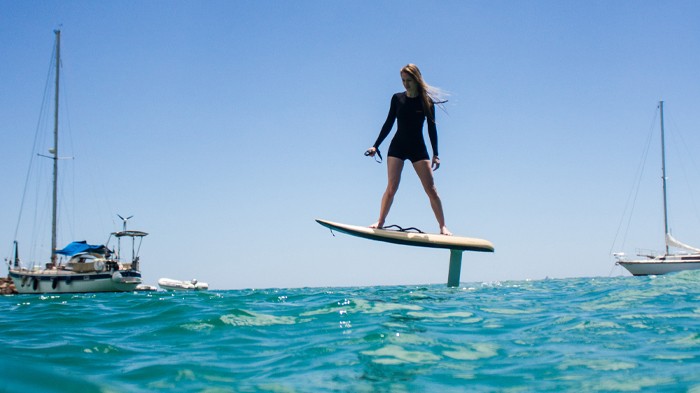 A man stading with Surfboard