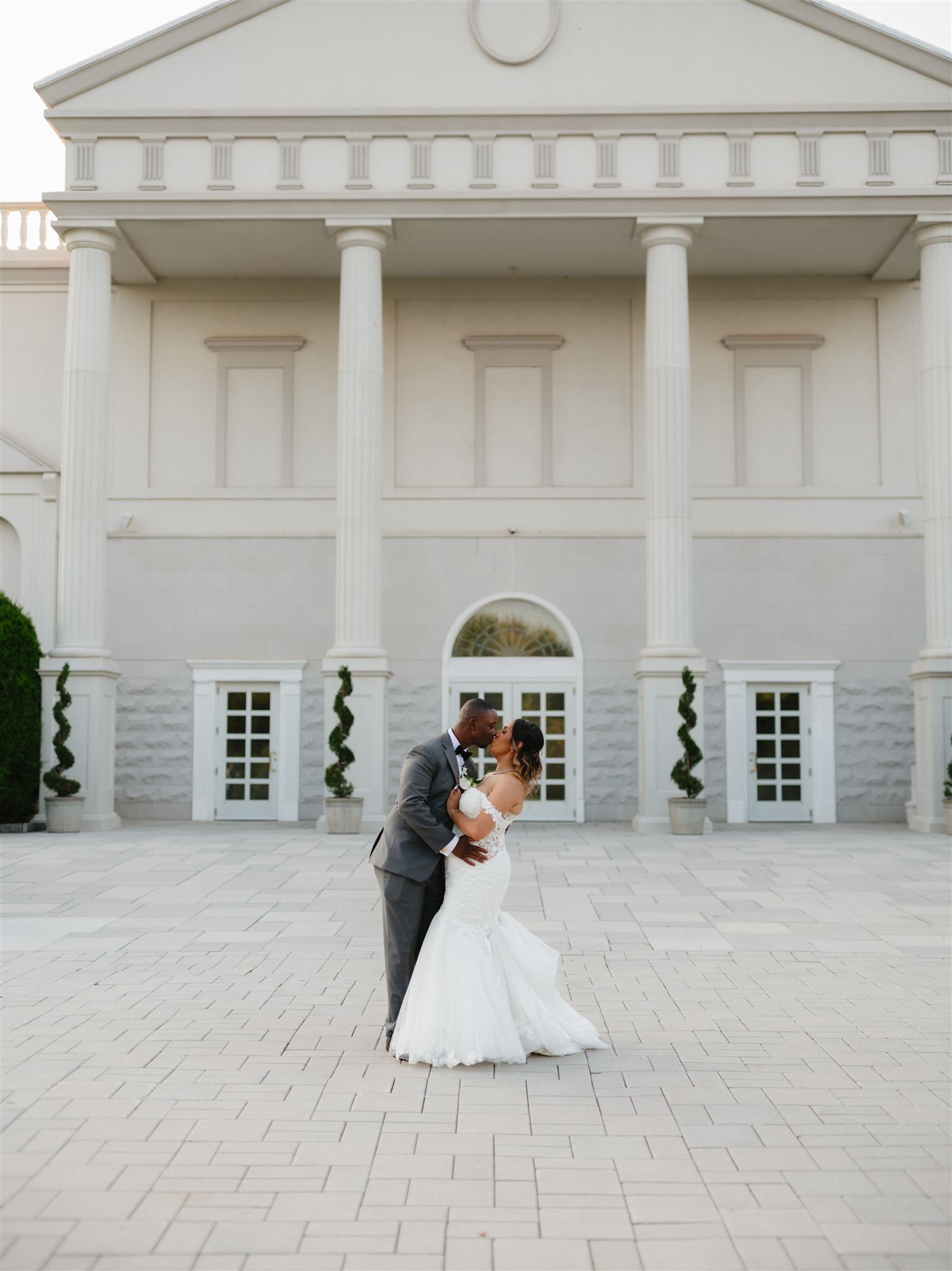 A couple in formal wedding attire embraces intimately in a vast.