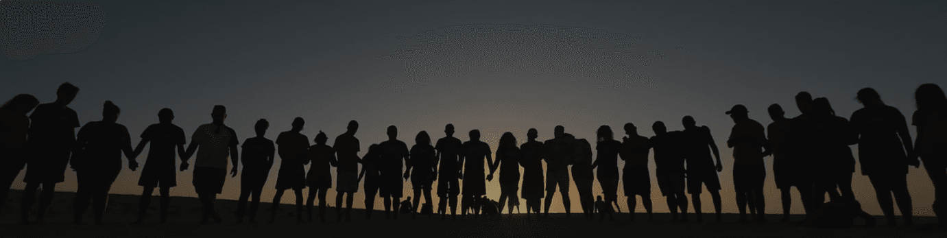 Menschen als Silhouetten beim Sonnenuntergang.