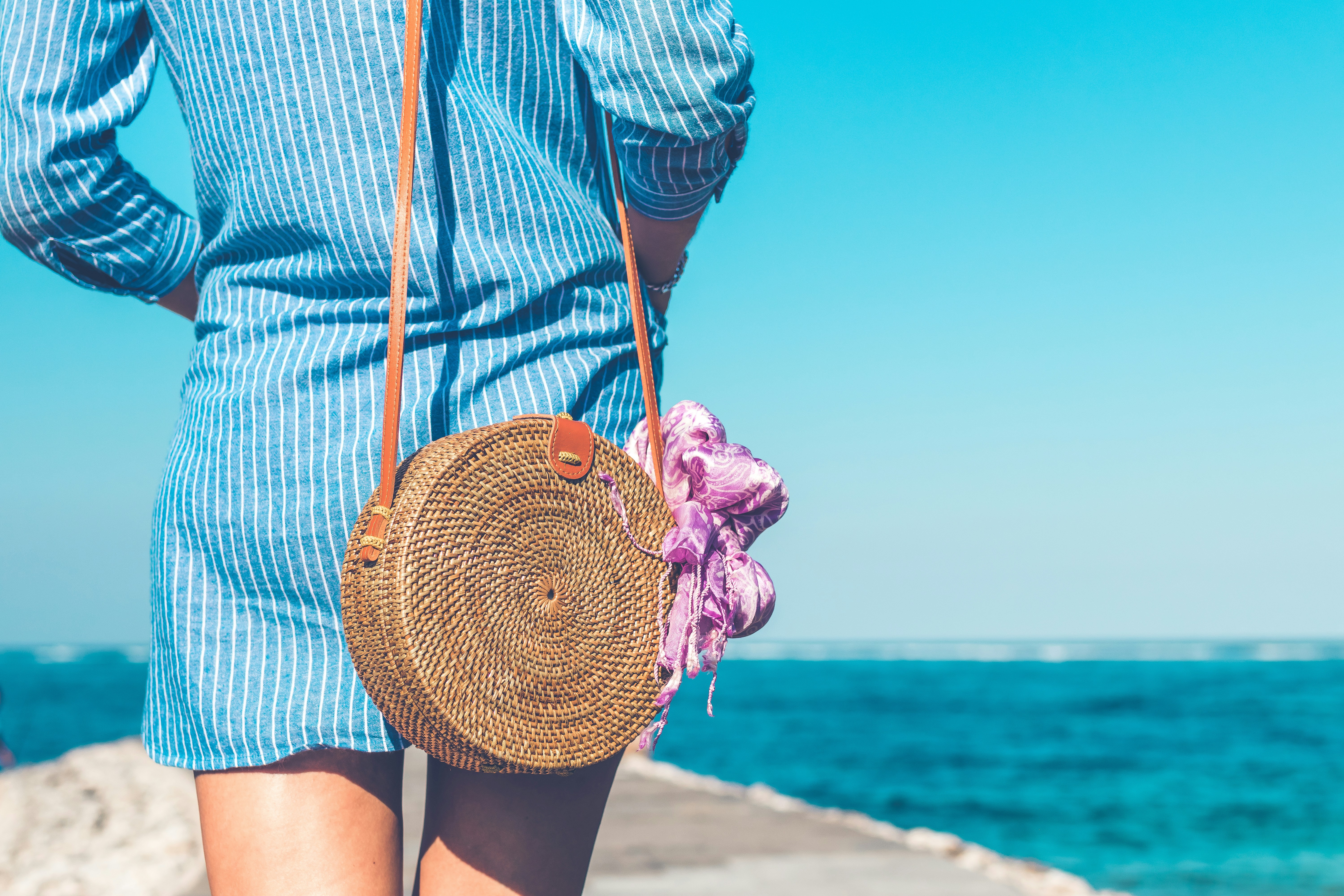 woman walking down a beach - Warm Weather Fall Outfits