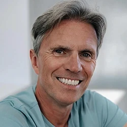 Professional headshot of a person in a formal setting.