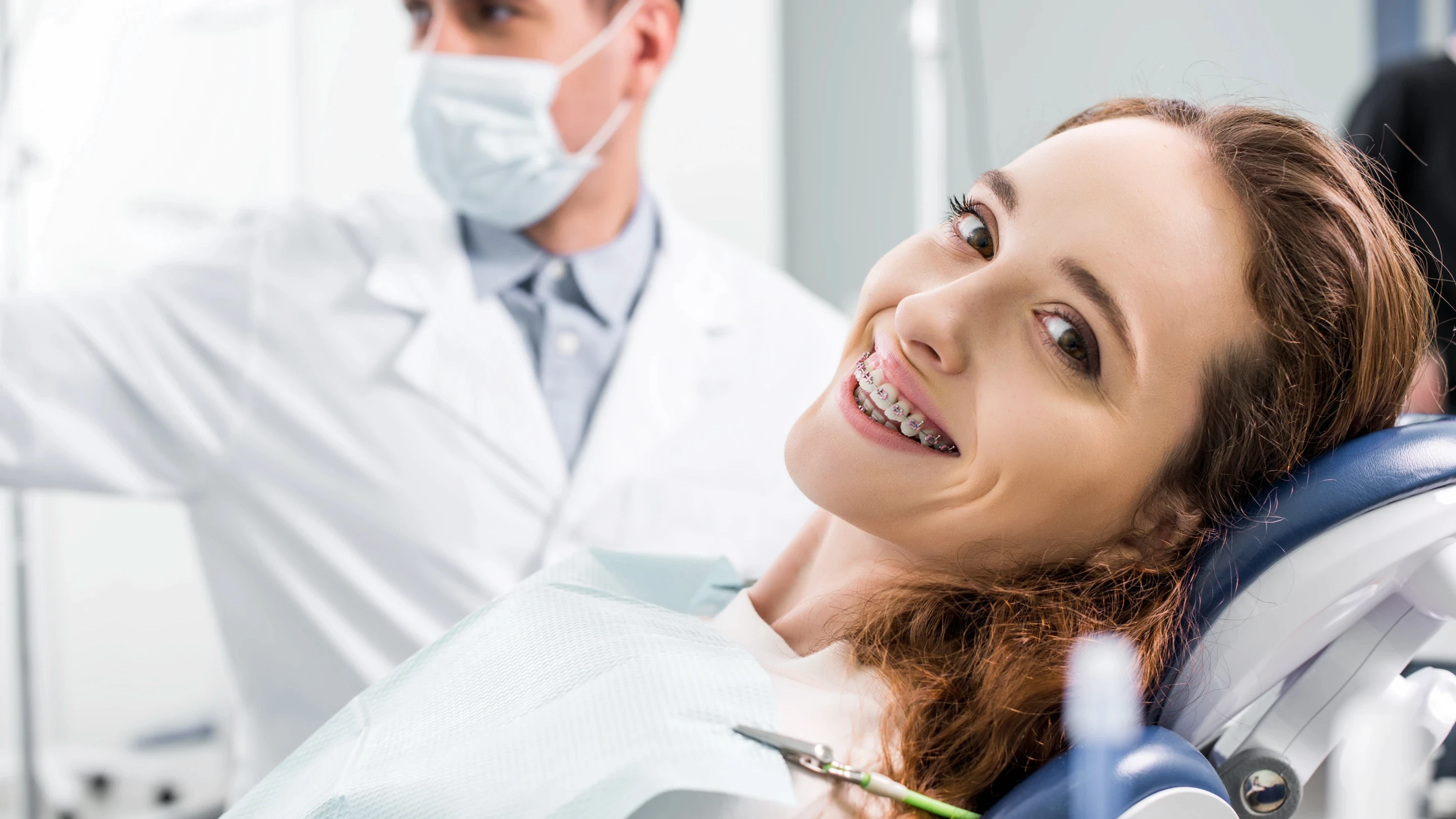 Kobieta z uśmiechem prezentująca efekty bondingu na swoich zębach.