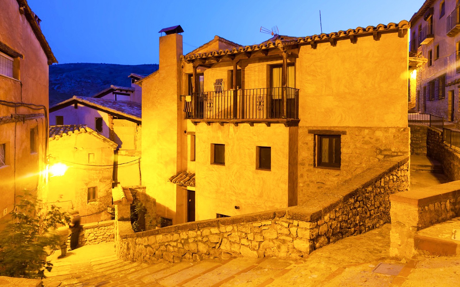 Alleyway in the Albaicín, Granada, illuminated at night with traditional houses.