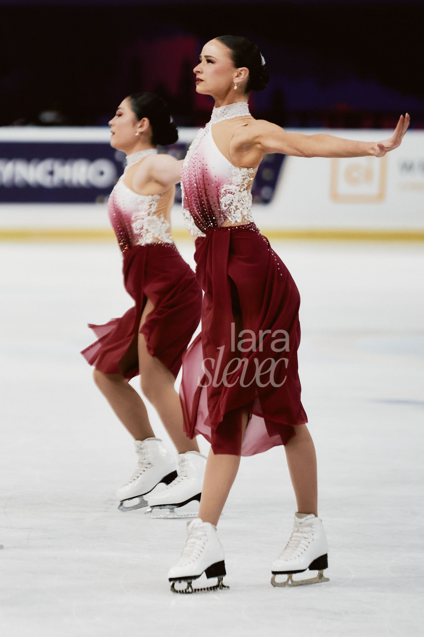 Zwei Synchroneiskunstläuferinnen, die in einer starken Pose seitlich zur Kamera stehen. Der Blick fokussiert und intensiv richtung Jury. Team Les Supremes. ISU Synchronized Skating Championships 2026 in Salzburg. Fotografiert von Lara Slevec.