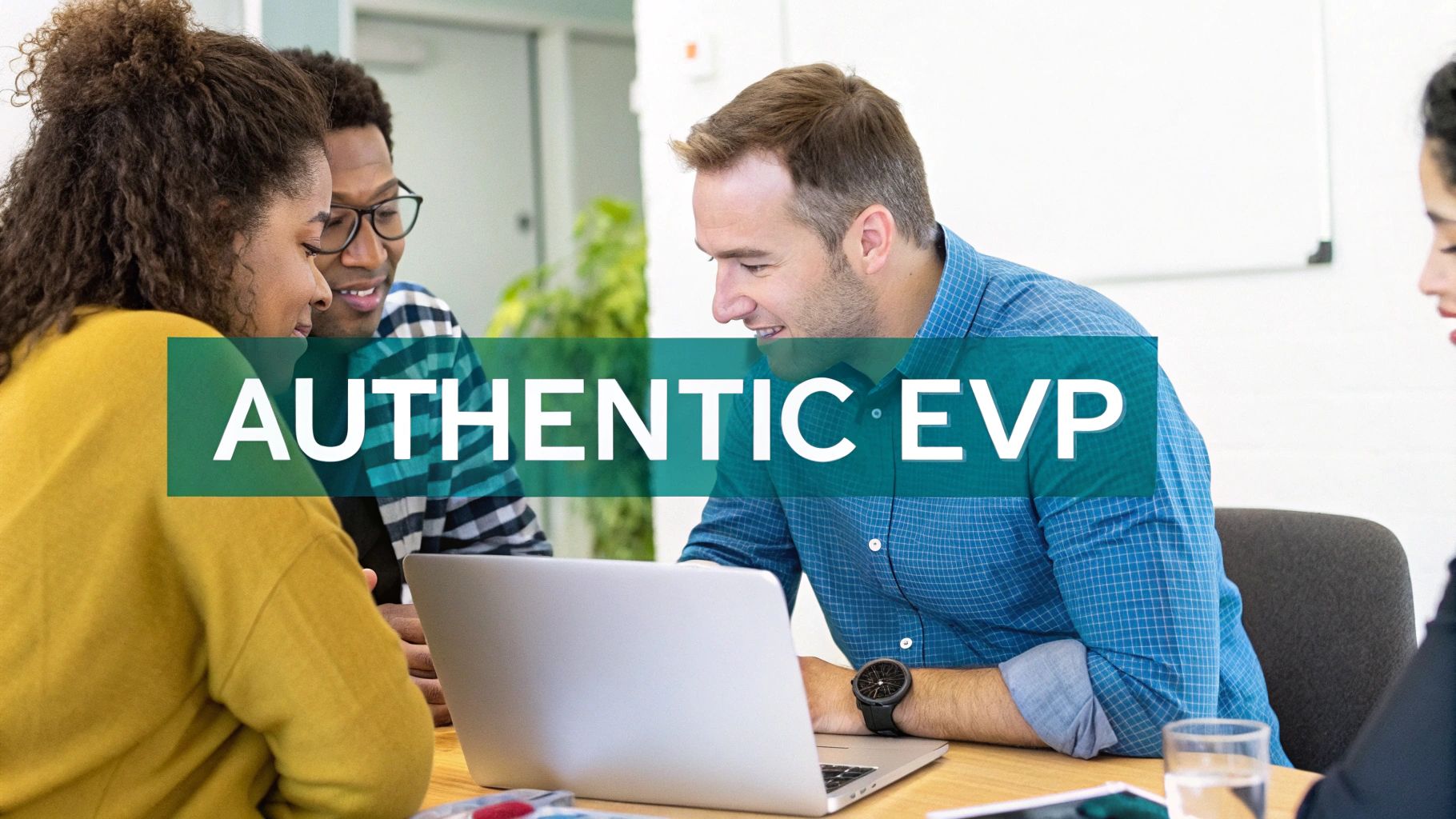 Diverse group of colleagues collaborating and looking at a laptop during a team meeting in an office.