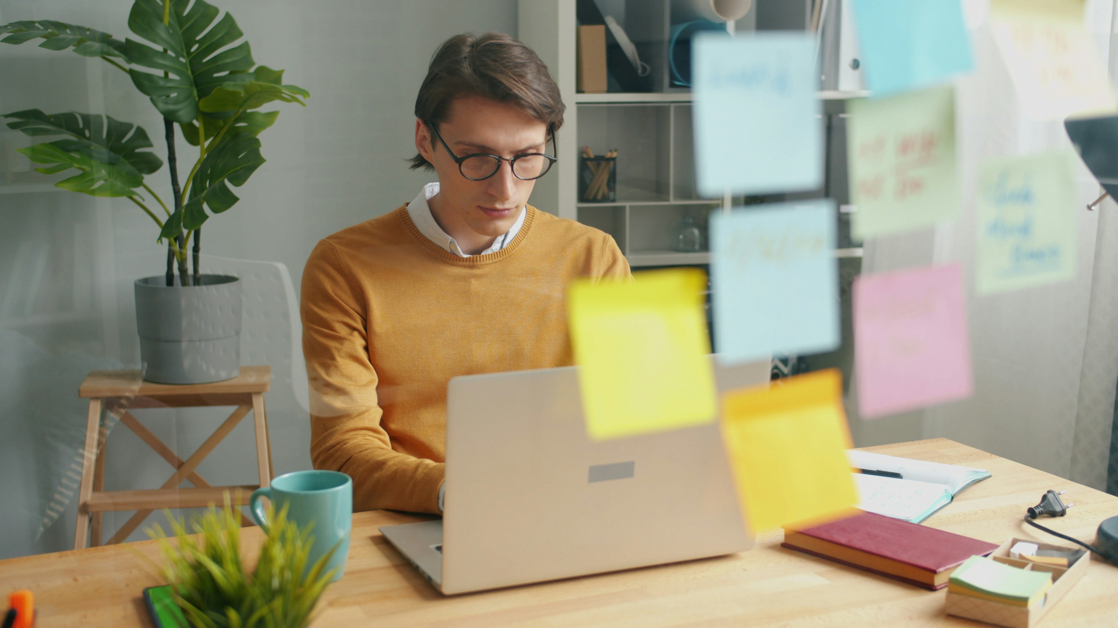 Man working on a laptop with sticky notes