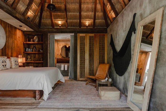 Habitación estándar en Nômade Tulum, destacando cama con almohadas.